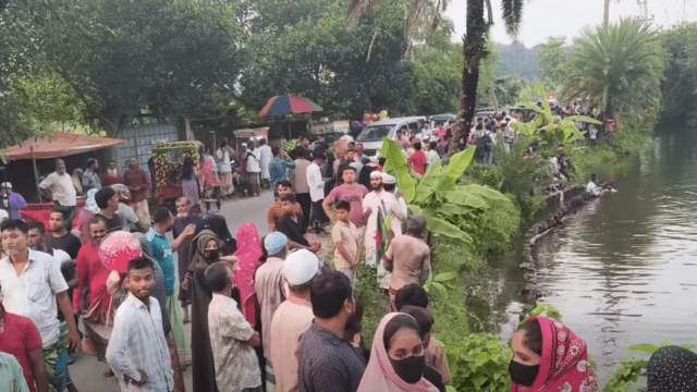 একটি পুকুরের পাশে মানুষের ভিড়