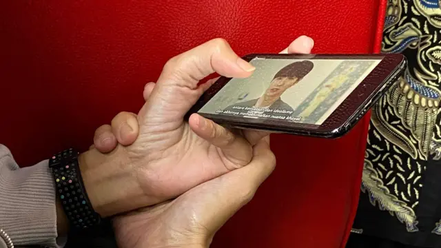 মোবাইল ফোনে কোরিয়ান ড্রামা দেখছেন একজন নারী।